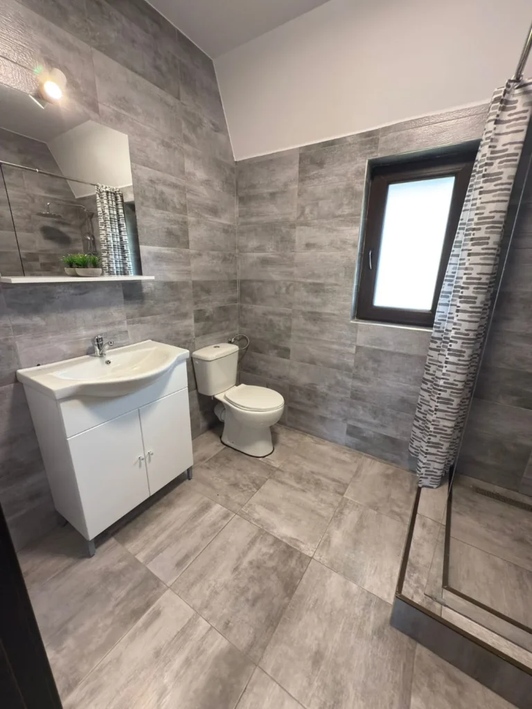 Baie amenajată cu cabină de duș și mobilier alb